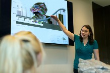 Woman standing in front of screen presenting seminar